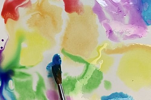 All the colors of the rainbow being painted in an abstract watercolor wash.
