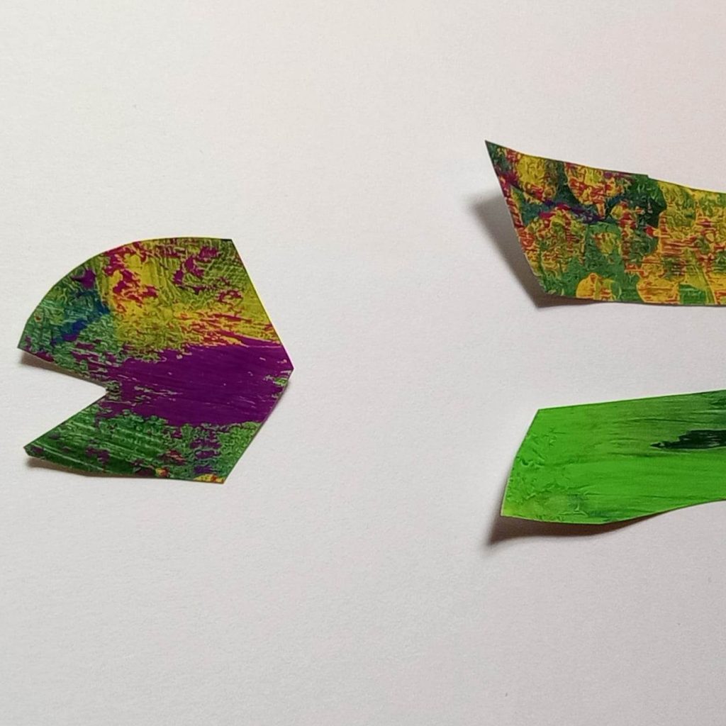 Rounded head with open mouth piece of my cut-paper fish. In greens, with yellow and magenta.