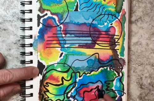 My hand drawing lines and other designs on a background of bright watercolor colors on a 52-Week Art Journal Journey art journal page.