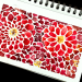 abstract red watercolor flowers with yellow centers filling spiral-bound art journal page